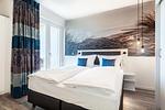 Schlafzimmer mit Zugang zum Balkon - Apartmentanlage Meerblickvilla 1-12 - Top-Hundeurlaub