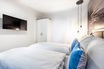 Schlafzimmer mit Flatscreen-TV - Apartmentanlage Meerblickvilla 1-12 - Top-Hundeurlaub