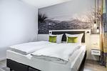 Schlafzimmer mit Boxspringbett - Apartmentanlage Meerblickvilla 2-26 - Top-Hundeurlaub