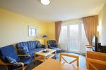 Wohnbereich mit Sofa, Sessel, Couchtisch und TV - Hus Inselkieker 213 - Top-Hundeurlaub