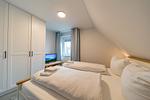 Schlafzimmer mit Kleiderschrank und TV - Hus Inselkieker 218  - Top-Hundeurlaub
