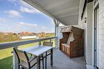 Überdachter Balkon mit Sitzgelegenheit und Strandkorb - Resort Deichgraf 31-06 - Top-Hundeurlaub