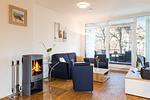 Wohn-Essbereich mit Couch und Kaminofen - DünenResort Binz 116 - Top-Hundeurlaub