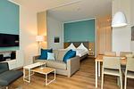 Wohn/ Essbereich mit Couch, Fernseher und Esstisch - Aparthotel Anna Düne 0-04 - Top-Hundeurlaub