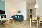 Wohn/ Essbereich mit Couch, Fernseher und Esstisch - Aparthotel Anna Düne 0-08 - Top-Hundeurlaub
