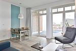 Wohn/ Essbereich mit Sessel  und Esstisch - Aparthotel Anna Düne 1-16 - Top-Hundeurlaub