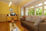 Wohn-Essbereich mit Couch und Flatscreen-TV - Dünenschloss 1-16 - Top-Hundeurlaub
