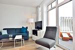 Wohn/ Essbereich mit Couch, Sessel und Fernseher - Aparthotel Anna Düne 2-35 - Top-Hundeurlaub