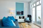 Wohn/ Essbereich mit Couch, Sessel und Fernseher - Aparthotel Anna Düne 2-38 - Top-Hundeurlaub