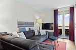 Wohnbereich mit Sofa, Couchtisch, TV und Zugang zum Balkon - Resort Deichgraf 31-07 - Top-Hundeurlaub