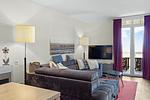 Wohnbereich mit Sofa, Couchtisch, TV und Zugang zum Balkon - Resort Deichgraf 31-07 - Top-Hundeurlaub