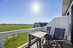 Balkon mit Tisch, Sitzgelegenheiten und Blick ins Grüne - Resort Deichgraf 27-21 - Top-Hundeurlaub