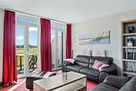 Wohnbereich mit Sofa, Sessel, Couchtisch und Zugang zum Balkon - Resort Deichgraf 27-21 - Top-Hundeurlaub