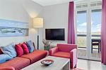 Wohnbereich mit Couch und Flatscreen-TV - Resort Deichgraf 31-13 - Top-Hundeurlaub