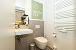 Badezimmer mit WC, Waschtisch und Spiegel - Apartmentvilla Anna See 1-05 - Top-Hundeurlaub