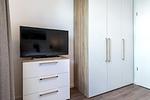Schlafzimmer mit Kleiderschrank und TV - Aparthotel Ostseeallee 3-22 - Top-Hundeurlaub