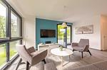 Apartment K15 Tao-Suite Krakow – modernes, lichtdurchflutetes Wohnzimmer mit türkisfarbener Akzentwand - Waldkauz - Top-Hundeurlaub