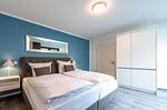 Apartment K15 Tao-Suite Krakow – ruhiges, modernes Schlafzimmer mit komfortablem Doppelbett, türkisfarbener Akzentwand - Waldkauz - Top-Hundeurlaub