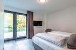 Apartment K15 Tao-Suite Krakow – helles, komfortables Schlafzimmer mit bodentiefen Fenstern und Zugang zur Terrasse - Waldkauz - Top-Hundeurlaub