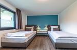 Apartment K15 Tao-Suite Krakow – ruhiges Schlafzimmer mit zwei komfortablen Einzelbetten und türkisfarbener Akzentwand - Waldkauz - Top-Hundeurlaub