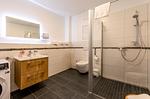 Apartment K15 Tao-Suite Krakow – modernes, großzügiges Badezimmer mit bodengleicher Dusche und hochwertigem Waschtisch - Waldkauz - Top-Hundeurlaub
