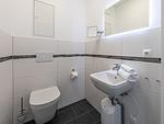 Apartment K15 Tao-Suite Krakow – separates Gäste-WC mit modernem Waschbecken und beleuchtetem Spiegel - Waldkauz - Top-Hundeurlaub