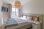 Ferienwohnung Küstenglück Aparthotel Zingst - Schlafzimmer mit Doppelbett und TV - Küstenglück - Top-Hundeurlaub