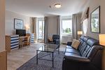 Ferienwohnung Bina Zingst - Blick ins offnene Wohnzimmer mit Couch, Sessel, Tv und Arbeitsplatz - Bina - Top-Hundeurlaub