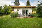 Ferienhaus Kleine Sommerliebe Waren (Müritz) - Holzterrasse mit Gartenmöbeln und Liegestühlen umgeben von Ziergräsern - Kleine Sommerliebe - Top-Hundeurlaub