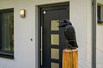 Ferienhaus Kleine Sommerliebe Waren (Müritz) - Dekoratives Eingangselement mit Vogel-Skulptur und schwarzer Haustür - Kleine Sommerliebe - Top-Hundeurlaub