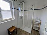 Badezimmer mit ebenerdiger Dusche, WC, Waschbecken, Spiegel - Haus Wikinger - Top-Hundeurlaub