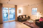 Sitzbereich im Wohnzimmer mit Zugang zum Balkon - Wohnung Nr. 08 Zum Anker - Top-Hundeurlaub