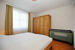 1. Schlafzimmer mit Kleiderschrank und Kinderbett - Wohnung 131 - Top-Hundeurlaub