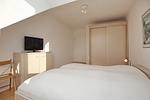 erstes Schlafzimmer mit Kleiderschrank und TV - Wohnung 120 - Top-Hundeurlaub