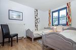 Schlafzimmer mit Einzelbetten und Stuhl - Wohnung 05-2 - Top-Hundeurlaub