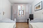 Schlafzimmer mit Einzelbetten und Kleiderschrank sowie Sitzgelegenheit - Wohnung 05-2 - Top-Hundeurlaub