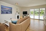 Wohnzimmer mit TV und Elektrokamin - Reethaus 15b - Top-Hundeurlaub