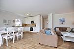 Wohnzimmer mit Essbereich, Sofaecke und Blick auf Küche - Reethaus 15b - Top-Hundeurlaub