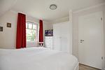 2. Schlafzimmer mit Doppelbett, Kleiderschrank und TV - Reethaus 15b - Top-Hundeurlaub