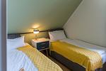 Schlafzimmer mit zwei Einzelbetten und Nachttisch - Haus am Schilf - Wohnung 6 - Top-Hundeurlaub