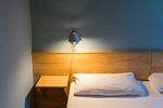 Modernes Schlafzimmer mit Bett und Nachttischlampe - Haus am Schilf - Wohnung 1 - Top-Hundeurlaub