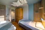 Schlafzimmer mit zwei Einzelbetten und natürlichem Holz - Haus am Schilf - Wohnung 1 - Top-Hundeurlaub