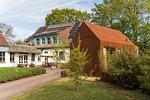 Außenansicht eines Ferienhauses mit rotem Anbau - Haus am Schilf - Wohnung 1 - Top-Hundeurlaub
