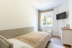 Helles Schlafzimmer mit Bett und Fernseher - Hoop - Top-Hundeurlaub