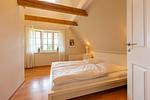 Schlafzimmer mit Doppelbett und Fenster - Künstlerhaus Rosenthal 02 - Top-Hundeurlaub