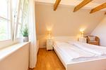 Helles Schlafzimmer mit Doppelbett und Stuhl - Künstlerhaus Rosenthal 02 - Top-Hundeurlaub