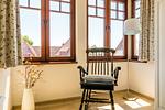 Helles Wohnzimmer mit Stuhl und Fenstern - Nele Nelsson Hus, Landhaus Haven Höövt - Top-Hundeurlaub