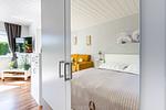 Schlafzimmer mit Bett und gemütlichem Sitzbereich - Sonnenblumenhaus 01 - Top-Hundeurlaub