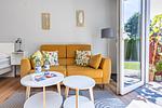 Wohnzimmer mit gelbem Sofa und Tisch - Sonnenblumenhaus 01 - Top-Hundeurlaub
