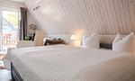 Schlafzimmer mit Doppelbett und Zugang zur Terrasse - Sonnenblumenhaus 02 - Top-Hundeurlaub